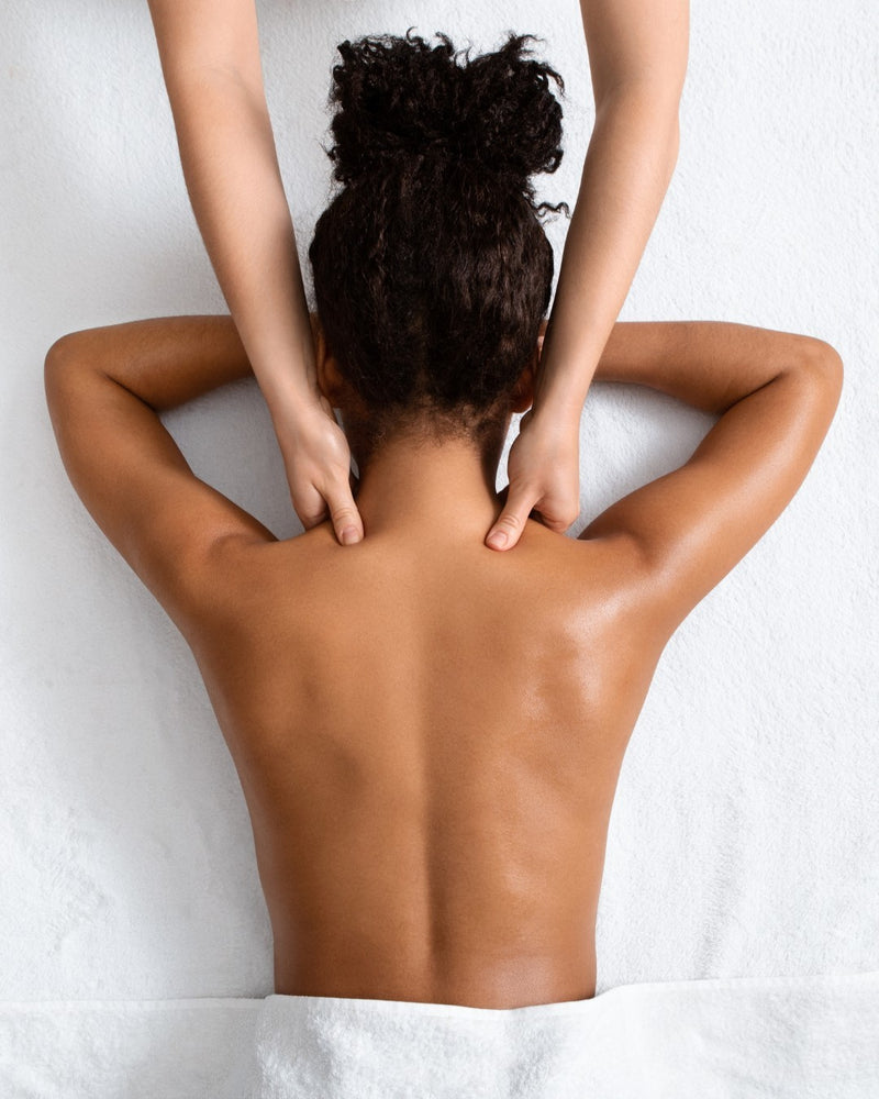 a woman in a red bikini and a hat sits poolside with her long, tan, smooth, and hairless legs in the pool 